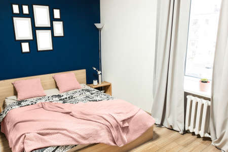 Interior of the room in light colors. Bedroom with a bed and a cot in colors classic blue 2020.の写真素材
