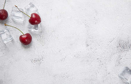 top view berry cherries and ice cube on a gray concrete background. Summer frash conceptの写真素材
