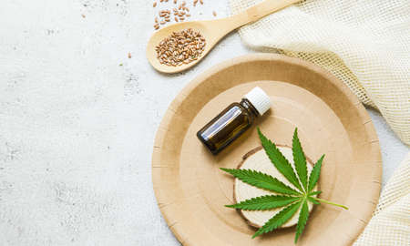 flat lay composition top view. Marijuana leaves, cannabis oil and Hemp seeds. Glass bottle with CBD oil, THC tincture. Cosmetics CBD oil.の写真素材