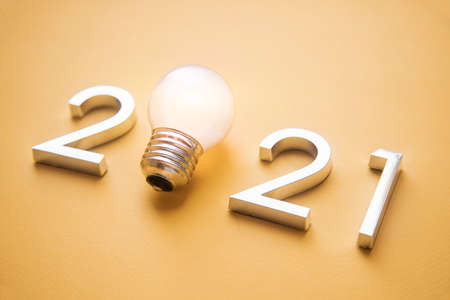 metal numbers 2021 with a burning light bulb. New ideas in the new year