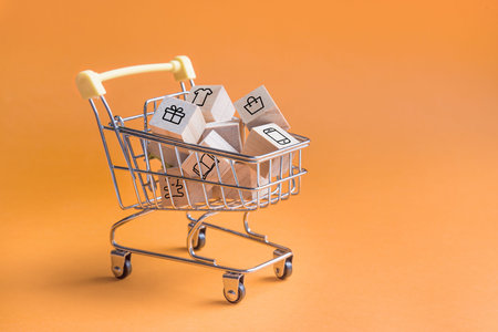 Online Shopping. Trolley basket from the supermarket on an orange background. home delivery