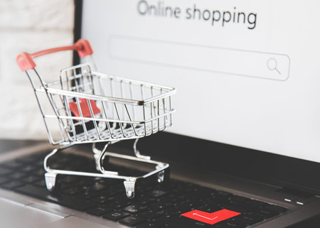 Online Shopping. shopping cart on a laptop keyboard. ordering and delivery of goods to your home and...