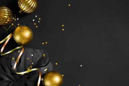 Christmas decorations, ribbons and Christmas balls on a black office table. plans and goals for...