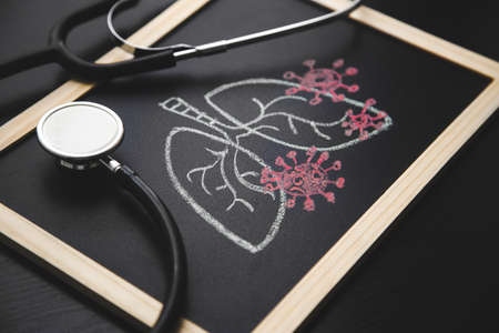 board with a draw of lungs and virus. stethoscope on the doctors deskの写真素材