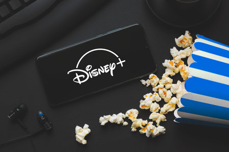 Ufa, Russia - October 7, 2020: Table with popcorn and disney plus logo. Disney is a global provider...