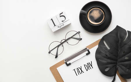Desktop top view. 15 April tax day. Calendar, glasses and a sheet of paper on a white table flat layの写真素材