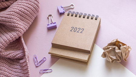 plan for 2022. Calendar , smart watch and office accessories on the table top view.