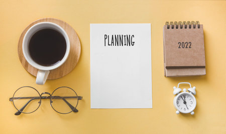 plan for 2022. Calendar and office accessories on the table top view.