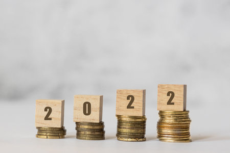 financial plan on 2022 year. Wooden cubes on coins, Budget planing concept.