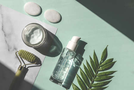 Cosmetic bottle containers with green herbal leaves, Natural beauty product concept. top view, flat lay.の写真素材