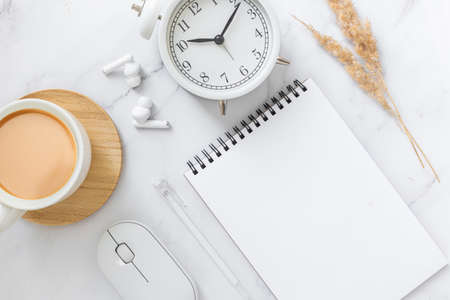 Blank sheet of paper notebook and cup on marble office desk.の写真素材