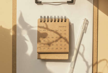 Beige neutral minimalist composition with calendar 2022. home office table and shadow leafの写真素材