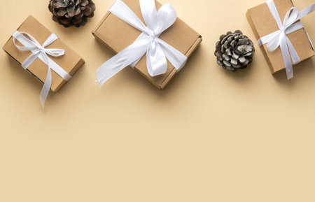 Christmas composition on beige background. Christmas gift with white ribbon, coffe cup. Top view,...