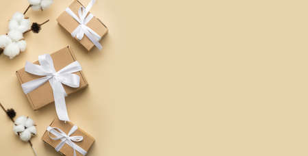 Christmas composition on beige background. Christmas gift with white ribbon, coffe cup. Top view, flat lay, copy spaceの写真素材