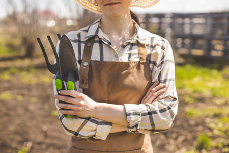 Farmer with tools in her hands, working in organic vegetables gardenの写真素材
