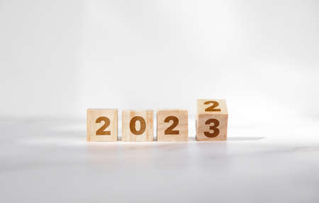 New year goals 2023, changes the number on a wooden cube. Resolutions, plan and goals, checklist concept. New Year 2023 template, copy spaceの写真素材