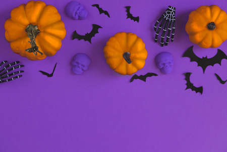 Halloween decorations bats, pumpkins and skulls on color background. Halloween concept. Flat lay, top view, copy spaceの写真素材