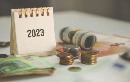 finances and plans for 2023. calendar and coins on the tableの写真素材