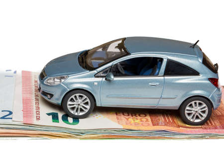 Toy car on money isolated on whiteの写真素材