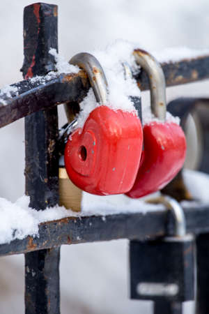 Red love locks on fence in snowの写真素材