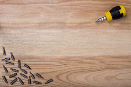 Top view screwdriver with set of bits on wooden table with copyspaceの写真素材