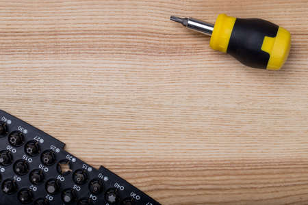 Top view screwdriver with set of bits on wooden table with copyspaceの写真素材