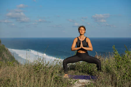 Young woman practicing yoga outdoorsの写真素材