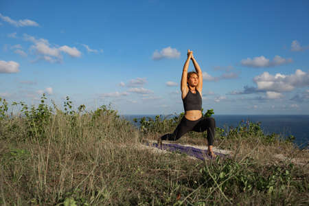 Young woman practicing yoga outdoorsの写真素材