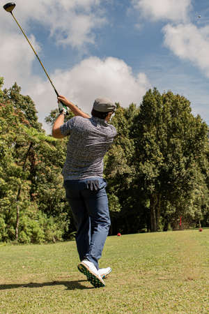 A man flying through the air on a golf courseの写真素材