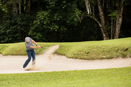 Professional golfer. hits the ball from the sand trapの写真素材