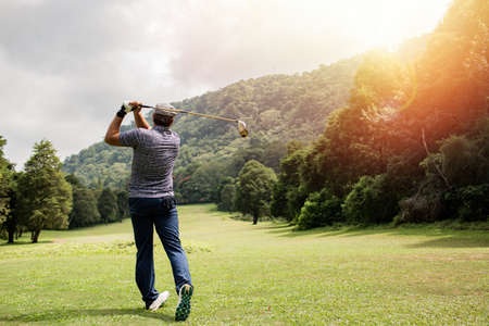 professional golfer taking a shotの写真素材