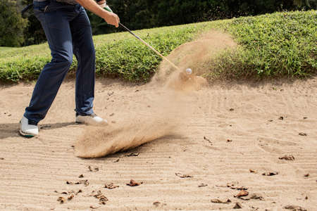 Professional golfer. hits the ball from the sand trapの写真素材
