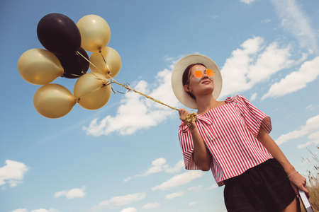 Bbeautiful girl holding balloons in her handsの写真素材