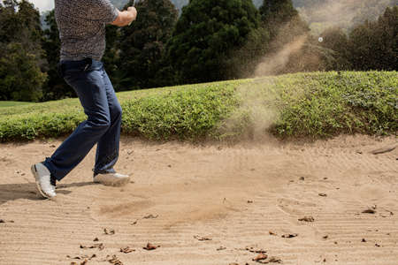 Professional golfer. hits the ball from the sand trapの写真素材