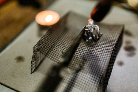 close-up. The jeweler makes a silver ringの写真素材