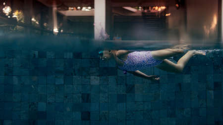 little girl swims in the poolの写真素材