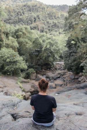 girl sits on a stone in the forest.の写真素材