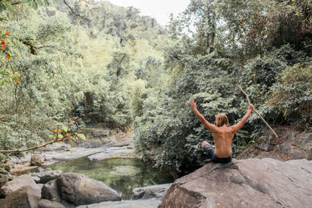 tourist sits on a stone in the forest.の写真素材