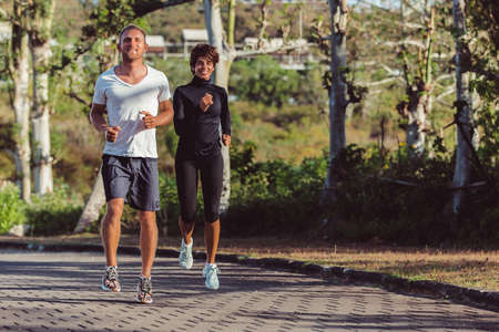 man and girl running in the parkの写真素材