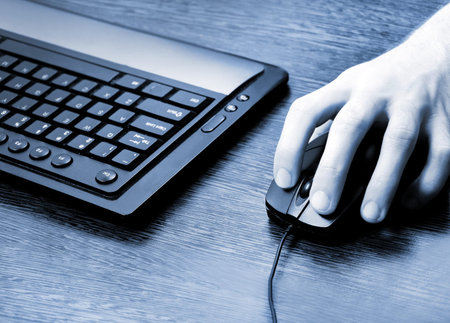 Desk with man hand on mouseの写真素材