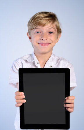 Young boy showing tablet at cameraの写真素材