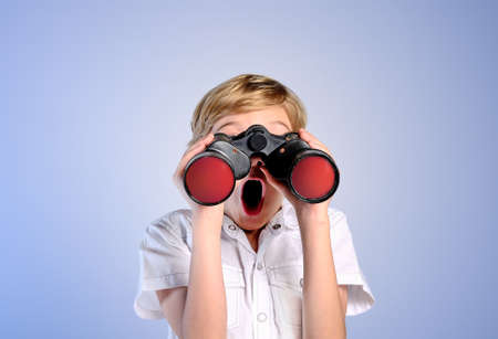 amazed young boy search on blue backgroundの写真素材
