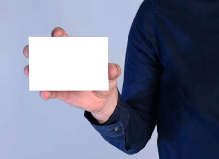 young man presenting card on blue backgroundの写真素材