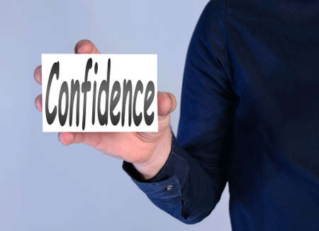 man showing confidence word on paperの写真素材