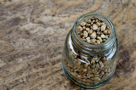 hemp seed in jar on wooden tableの写真素材