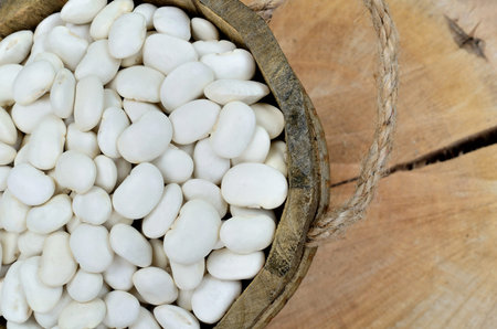 white beans in bucket on wooden tableの写真素材