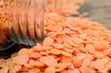 red lentil on wooden table with jarの写真素材