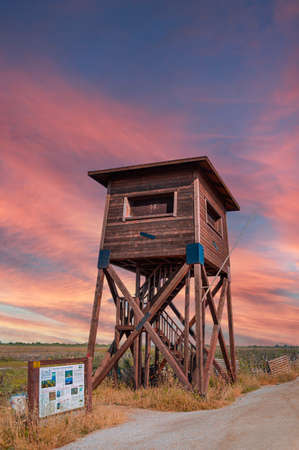 A wooden watchtower lookout tower on a field and a swamp created by the Axios river deltaの写真素材