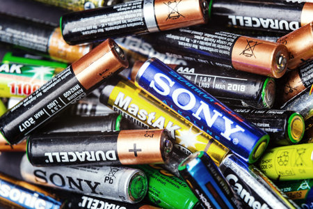 KYIV, UKRAINE - March 03, 2016: Many used Colorful AA and AAA sized batteries in a pile at black...