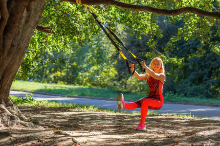 Outdoor exercises on fitness strapsの写真素材